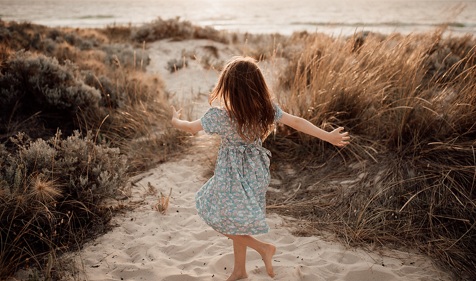 girl on beach looking happy facing the sun