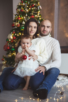 Семейни коледни снимки край украсената елха