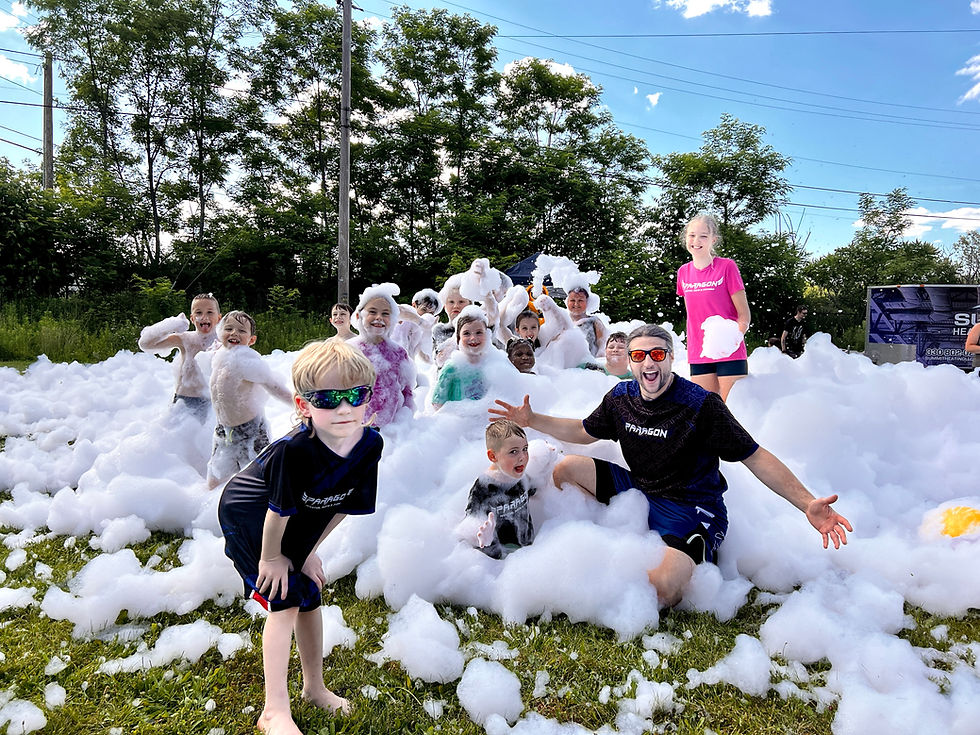 the students at Paragon Martial Arts and their ecstatic instructor, Matt, enjoying a foam party on the front lawn