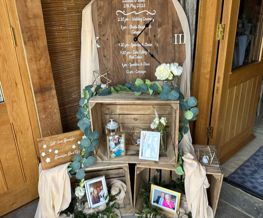 Rustic wedding décor featuring personalised order of the day clock