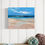 Thumbnail: Beach Dreams 2025 Painting displayed on a white wooden wall above a shelf with seaside ornaments