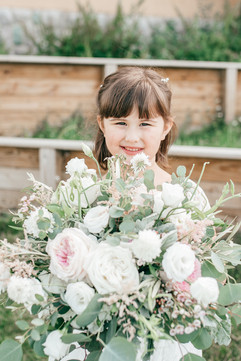 daughter and flower girl holding moms bouquet holding the brides bouquet. Absolutely adorable. Photographed by Aspen Kate Photogrphy