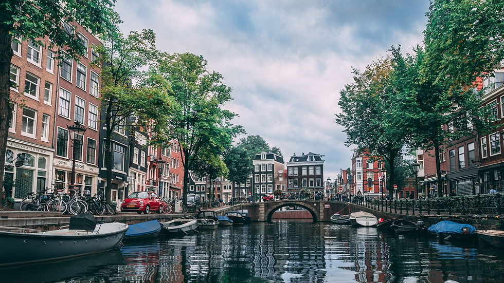 Canal d'Amsterdam bordé de maisons typiques et de vélos, aux Pays-Bas