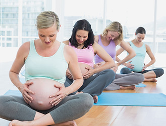 Pregnant women sitting on mats touching