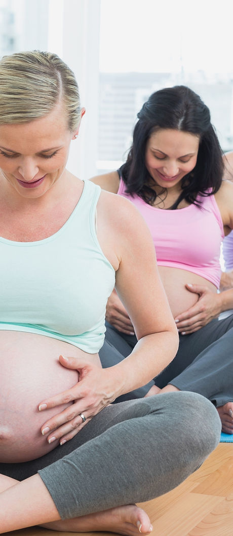 Pregnant women sitting on mats touching