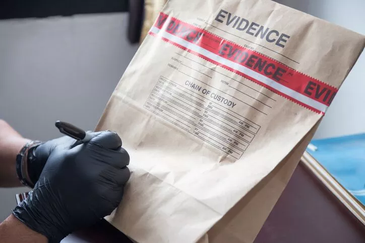 An investigator writing on an evidence bag