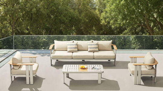 HIGOLD Pardee outdoor sofa set with light cushions and coffee tables on a tree-lined terrace.