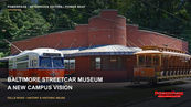 An orange-and-white streetcar and a wooden open-sided streetcar stand on tracks outside a brick museum carhouse.