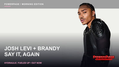 Josh Levi poses with braided hair and a black mesh top against a pale background.