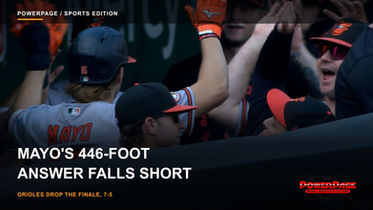 Baltimore Orioles infielder Coby Mayo in a black jersey celebrating with teammates near the dugout