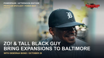 Zo! smiling outdoors in a gray shirt and cap.