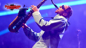 Masego playing saxophone onstage with the official PowerPage editorial logo