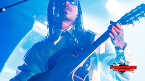 Steve Lacy playing guitar onstage with the official PowerPage logo.