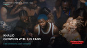 Khalid looks up toward the camera, wearing blue hair and a sleeveless top while surrounded by people.