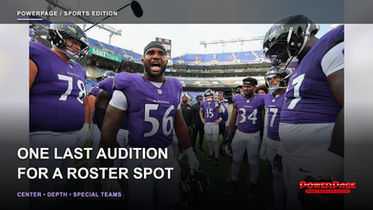 Baltimore Ravens players in purple uniforms gather in a huddle on the field at M&T Bank Stadium