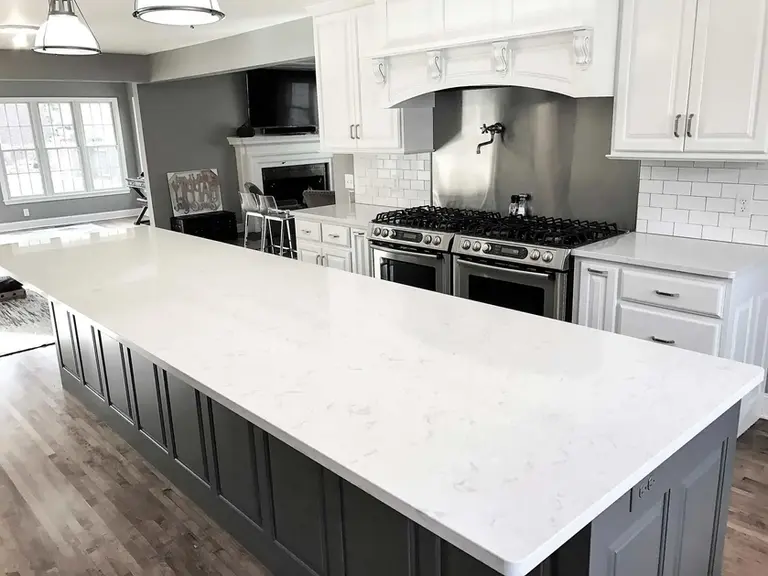 White quartz kitchen countertop with polished edge and white cabinets in Queens