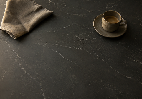 Dark charcoal porcelain countertop styled with a coffee cup and linen