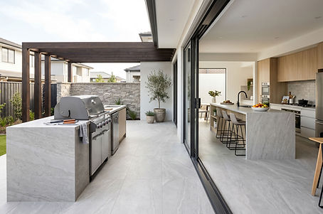Porcelain surface on an outdoor BBQ island continuing into an indoor kitchen