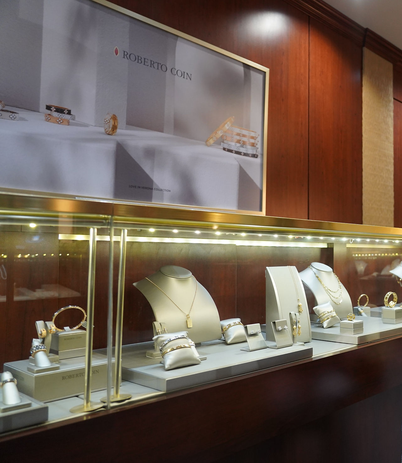 Jewelry display case with necklaces, bracelets, and earrings on display. Gause and Son.