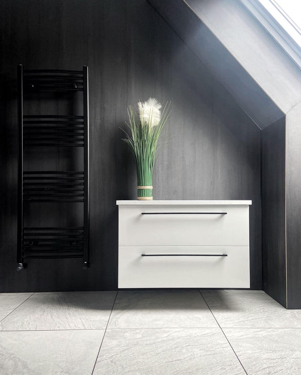 Floating white cabinets and drawers with black walls creating a high contrast feeling for a sleek and modern bathroom that feels stylish and unique.