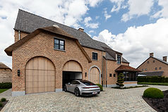 Woning met een kruising tussen modern en landelijk, zwarte steel look ramen en afrormosia poorten en inkomgeheel