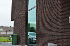 Ramen met profielen van Reynaers Aluminium op donkerbruine gevel