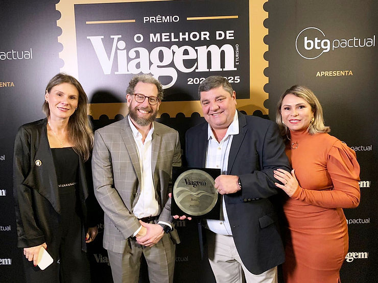 Imagem do prefeito Josmail Rodrigues ao lado da secretária de Turismo Juliane Salvadori durante a cerimônia de premiação da Editora Abril, onde Bonito foi reconhecido pela 18ª vez como Melhor Destino de Ecoturismo. Ambos posam sorridentes com o troféu em mãos, simbolizando o trabalho conjunto em prol do turismo sustentável na cidade.