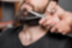 hairstylist-s-hand-cutting-man-s-beard-with-scissors