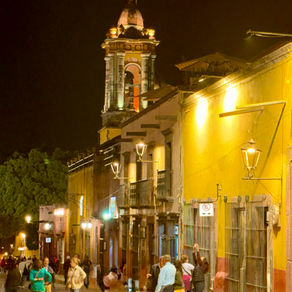 Busy, well lit street in San Miguel de Allende after dark