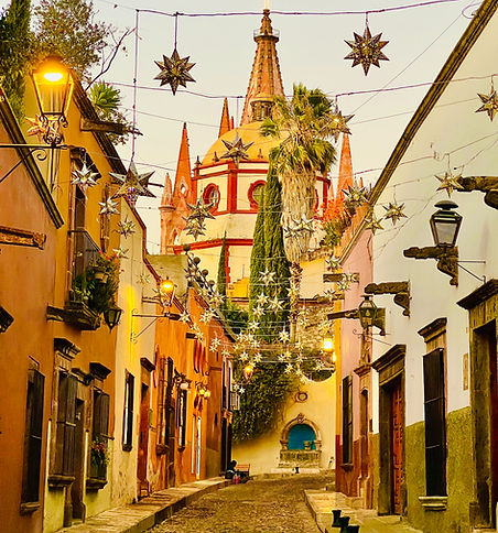 Street view down Aldama looking at the back of the Parroquia with Christmas decorations. strung overhead