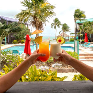 [Tropical welcome drink served at X'Tan Ha Resort on Ambergris Caye, Belize — included with every Ambergris Caye Vacation Package reservation