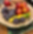 A colorful bowl filled with a variety of fresh fruits, including plums, peaches, and a squash