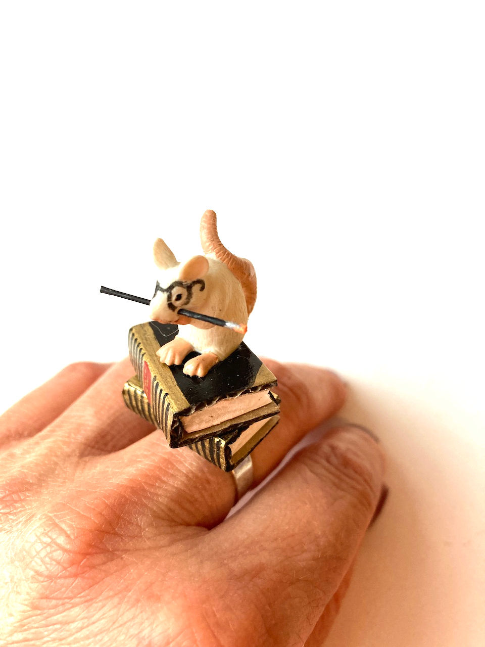 Thumbnail: bijou avec livre miniature et raton à lunettes sur les livres