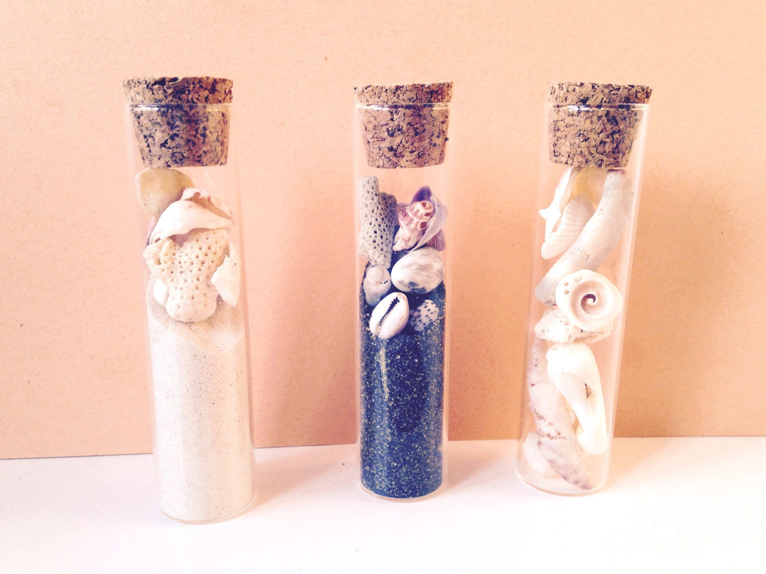 Petite décoration tubes de verre, sable blanc, sable noir, et coquillages