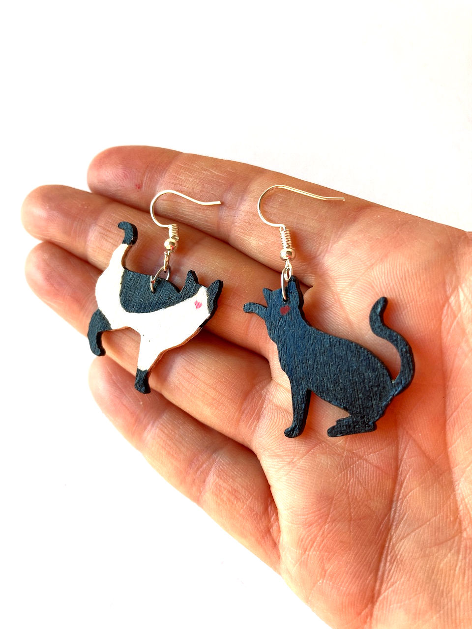 Thumbnail: main avec les boucles pendentifs chat noir et chat noir et blanc