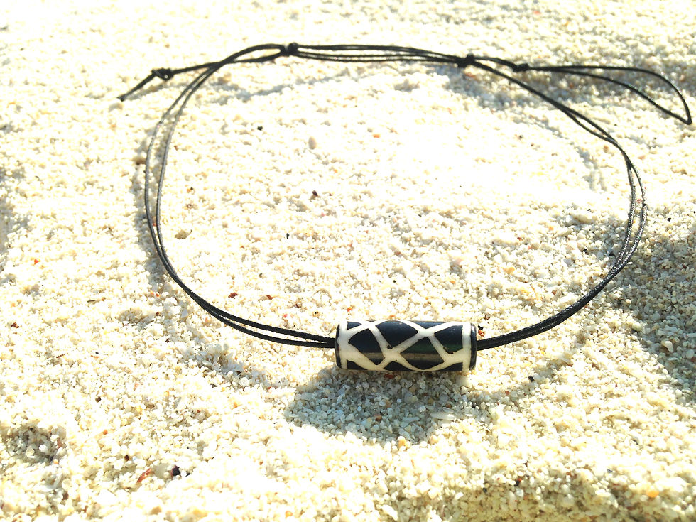 Thumbnail: collier posé sur le sable noir et blanc ras du cou cordon noir