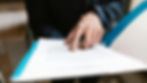 a person pointing on white paper