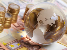 Imagem de uma mesa com dinheiro e um globo terrestre em cima