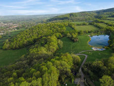 an aeriel photo shows mendip activity centre's site in the mendip hills with an artistic impression of a lake gently built into the landscape, surrounded by woodland and fields