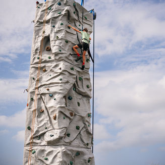 Tall mobile climbing wall set up outdoors for climbing tower hire in Somerset