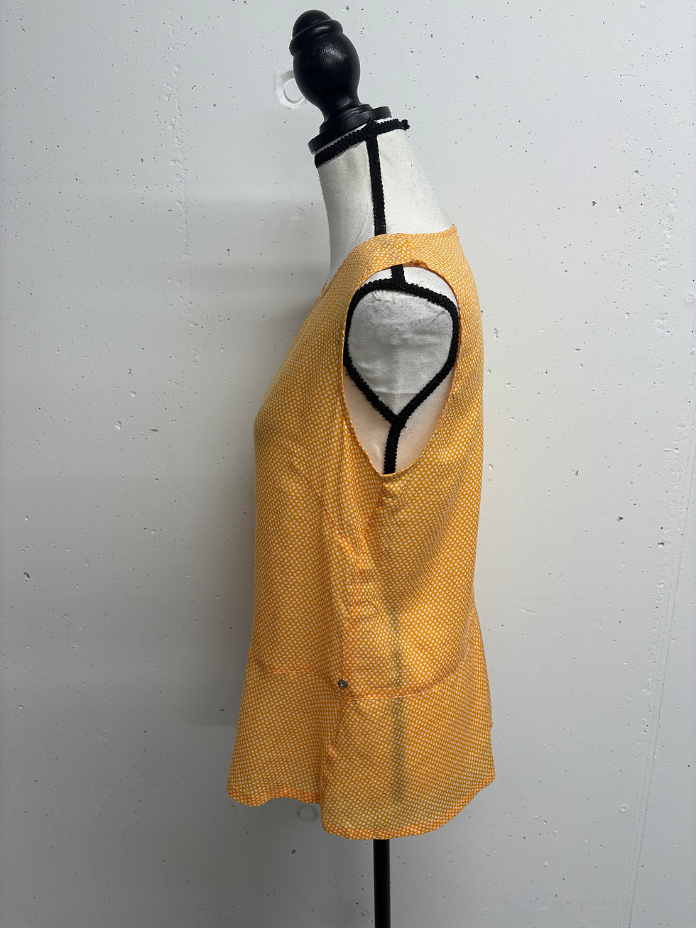 Gelbes Top auf einer Schaufensterpuppe vor weißem Hintergrund.