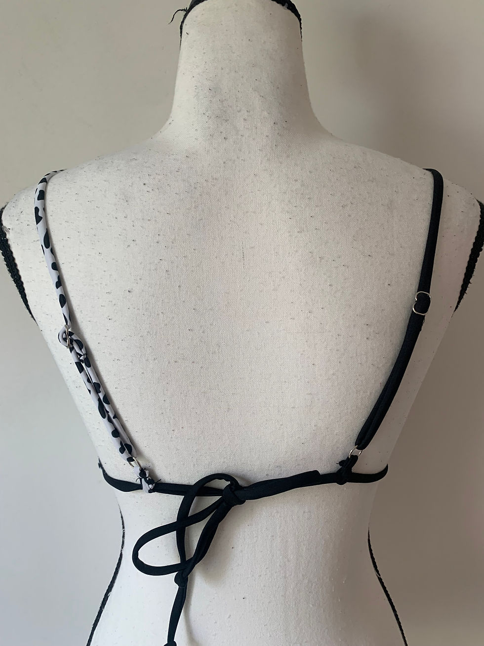 Miniaturbild: Rückansicht eines schwarzen Bikinis mit Spaghettiträgern auf einer Schneiderpuppe