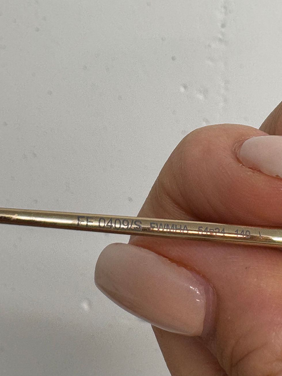 Miniaturbild: Nahaufnahme einer goldenen Brille mit Aufschrift: FS 04001S CHINA 54[]18 120-1.