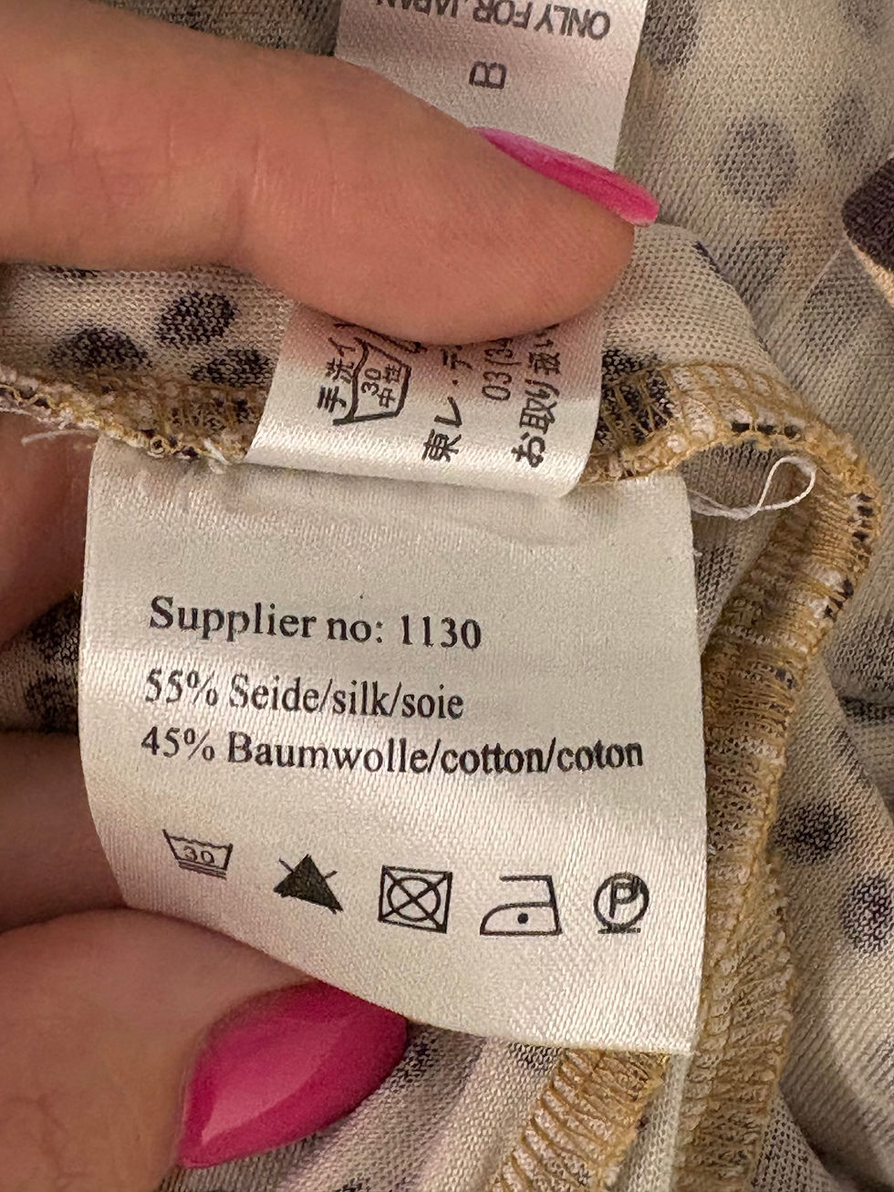 Miniaturbild: Kleid Etikett mit Aufschrift: Supplier no: 1130, 55% Seide, 45% Baumwolle, Waschsymbole.
