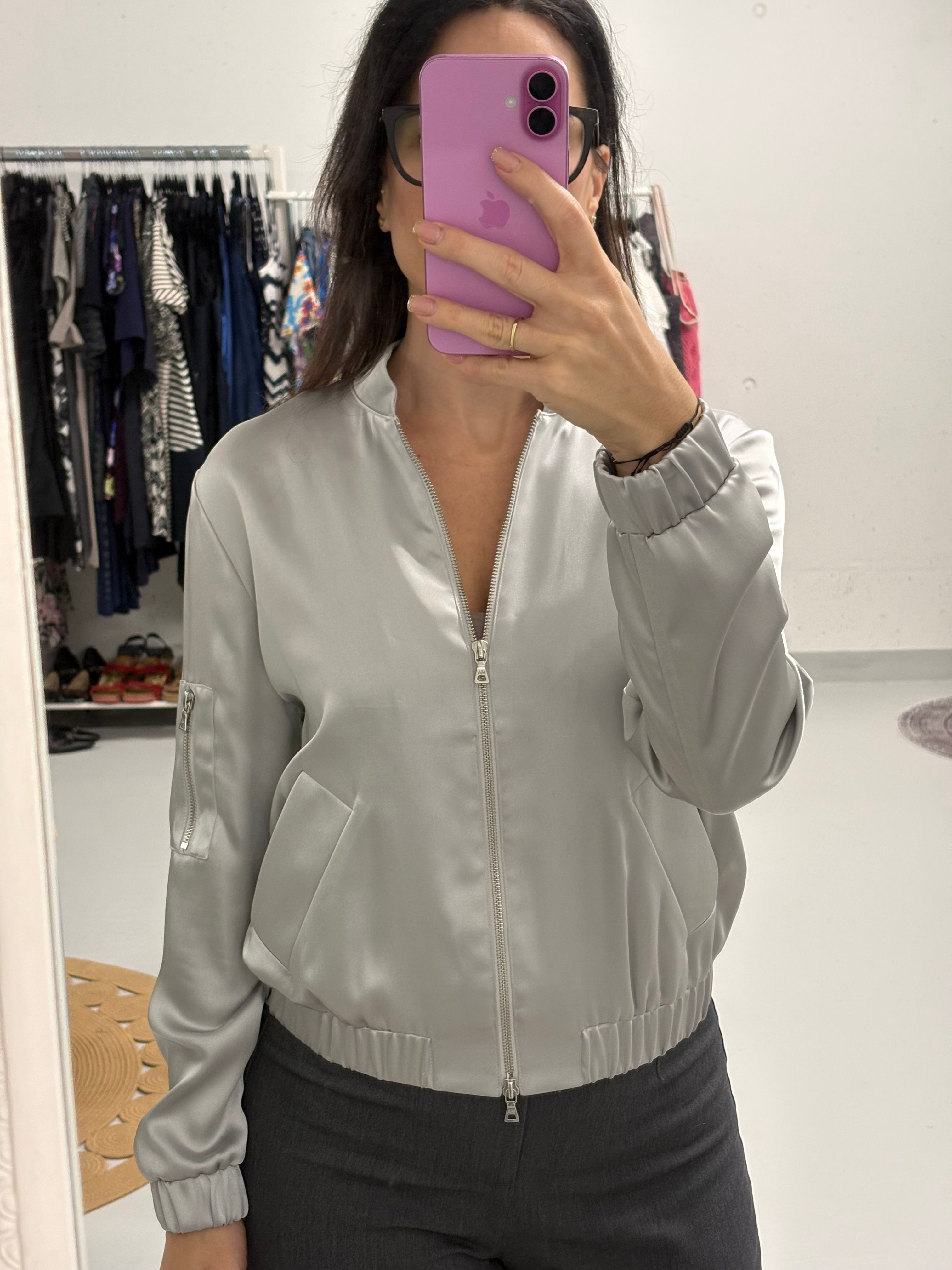 Frau im Spiegel mit silberner Jacke, MARC O`POLO Hose, vor Kleiderschrank.