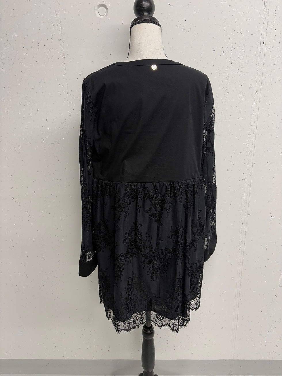Miniaturbild: Schwarzes Damenkleid mit Spitze, Rückansicht, vor weißem Hintergrund drapiert.