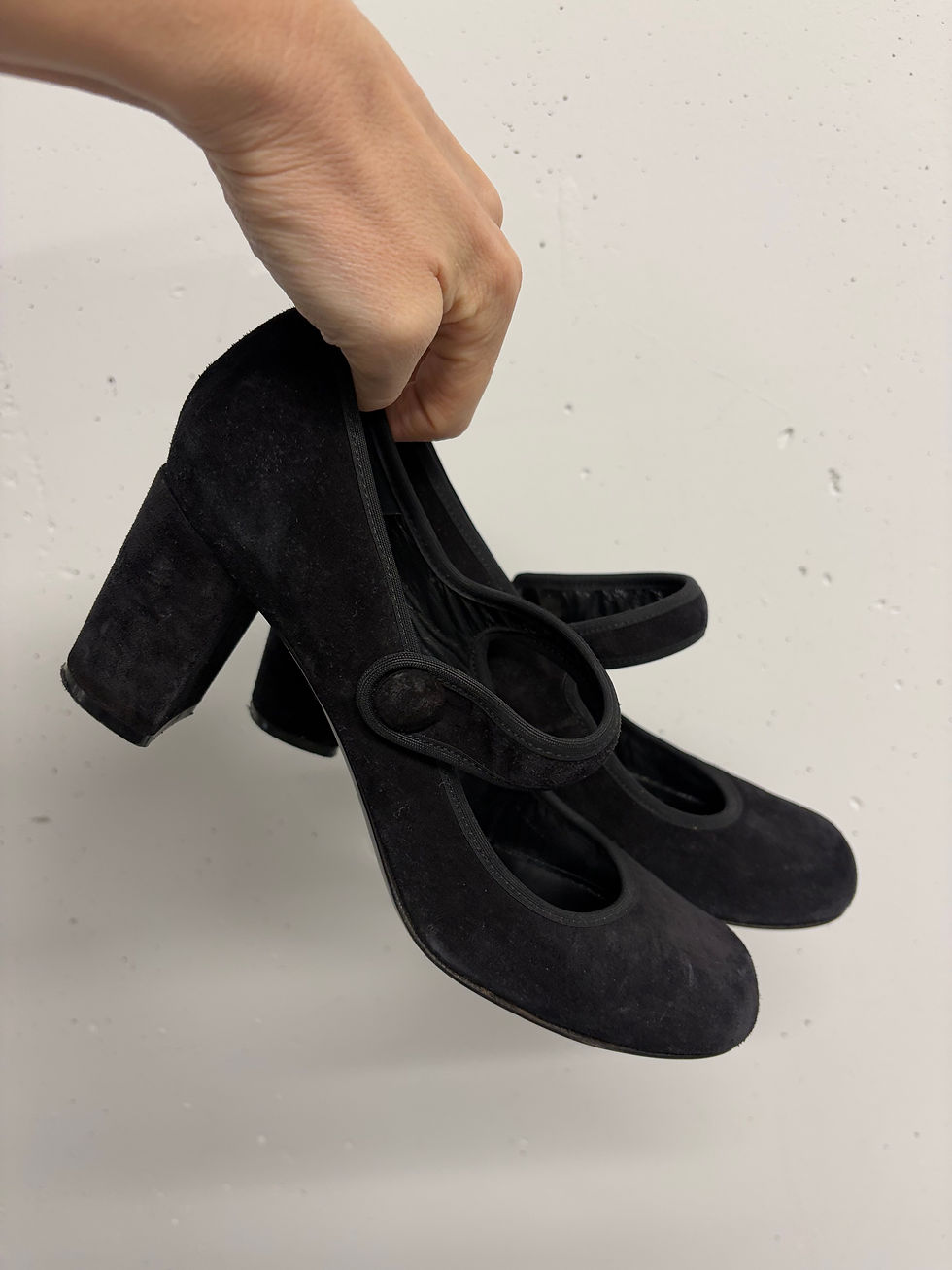 Hand hält schwarze MIU MIU Plateausandalette Gr. 40, Blick auf die Schuhe, Details.