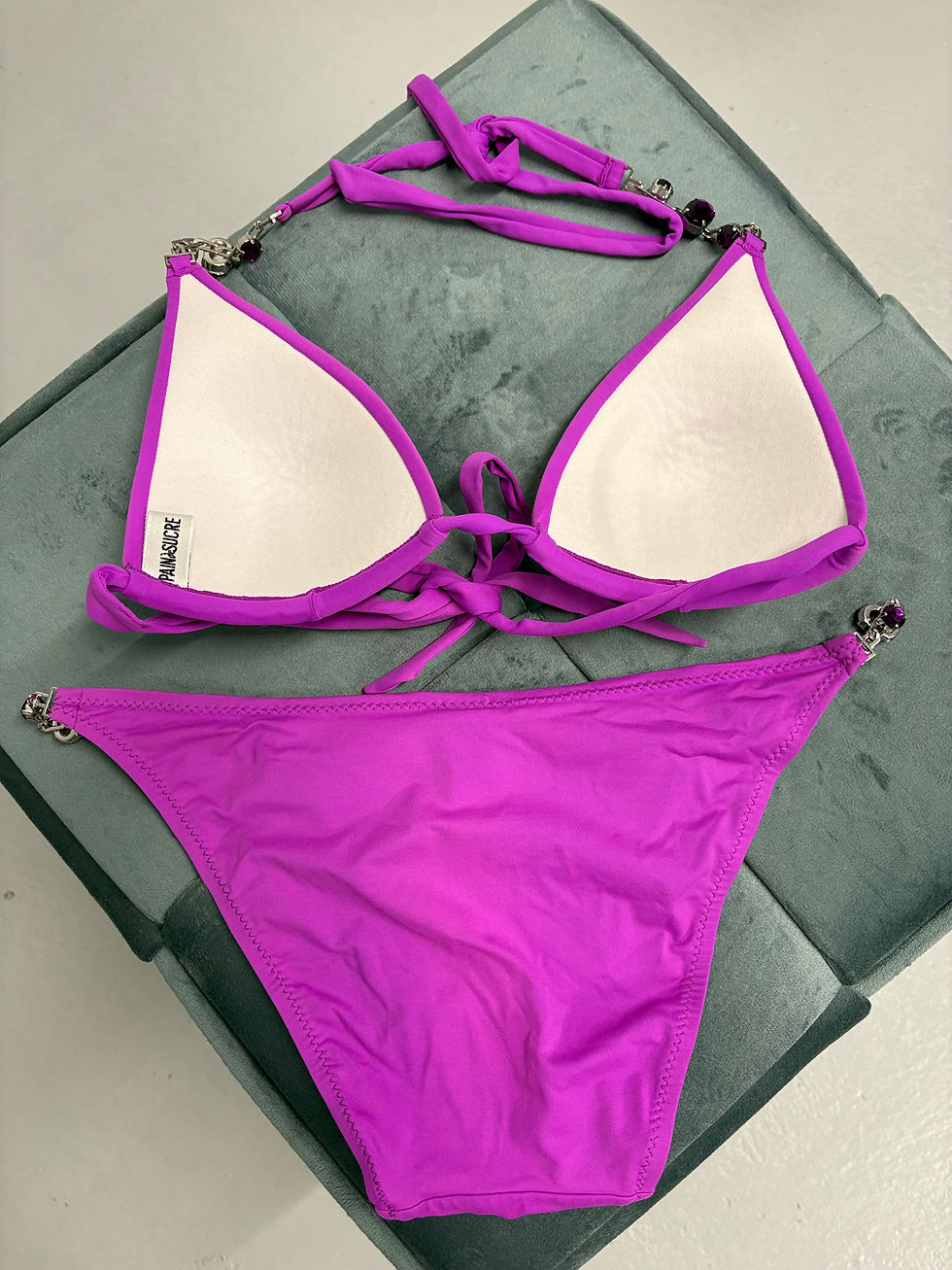 Miniaturbild: Lilafarbener Bikini auf grünem Kissen, Sommer Badebekleidung entspannt präsentiert
