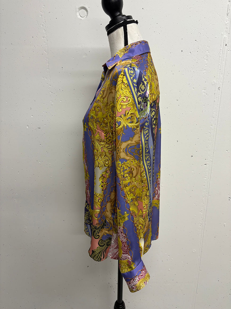 Gelbes und blaues Hemd mit floralem Muster auf einer Büste.