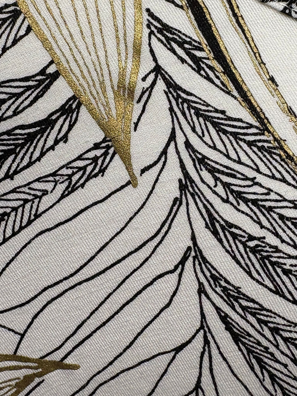 Miniaturbild: Nahaufnahme eines Stoffes mit schwarzen und goldenen Blattmuster Details.